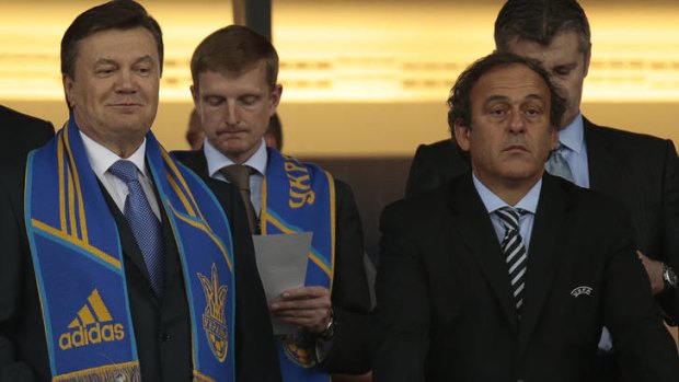 Shrugging off snub ... Ukrainian President Viktor Yanukovych, left, and UEFA President Michel Platini at Monday's match.