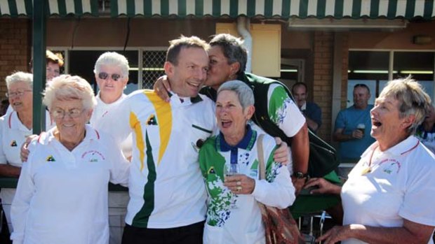 On a roll . . . Tony Abbott charms the ladies at the Kallangur Bowling Club in Queensland yesterday.