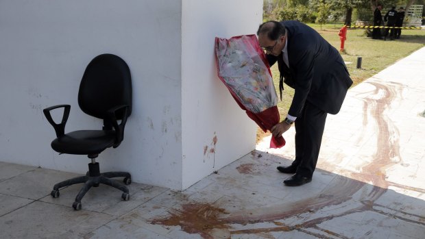 Souheil Alouini, a member of parliament, lays flowers next to a blood stain at the Bardo Museum in Tunis, Tunisia.
