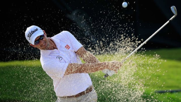 Adam Scott of Australia hits a bunker shot on the 11th hole during the weather-delayed first round of the World Golf Championships in Florida.