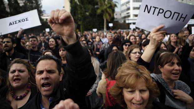 Employees of the Bank of Cyprus hold signs reading "shame" at Tuesday's protest in Nicosia.