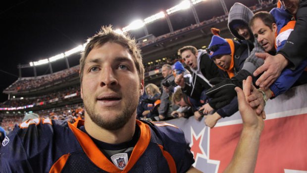 High fives .... Tim Tebow acknowledges the fans after his team's win over the Pittsburgh Steelers.