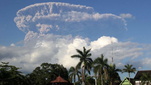 A giant cloud of ash and steam rise from erupting Sangeang Api volcano seen from Bima town on Sumbawa island.