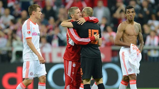 Bayern Munich's midfielder Bastian Schweinsteiger embraces his teammate and Dutch midfielder Arjen Robben.