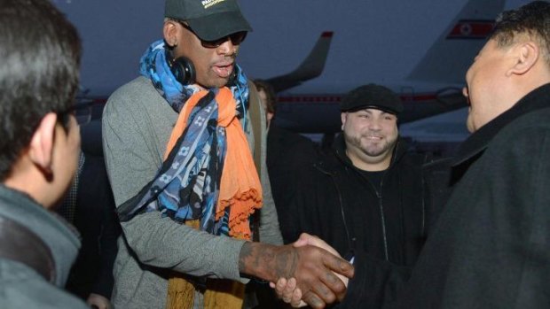 Former basketball star Dennis Rodman greets officials at Pyongyang airport on Thursday.