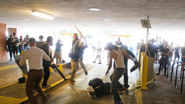 DeAndre Harris, bottom is assaulted in a parking garage beside the Charlottesville police station after a white nationalist rally was disbursed by police, in Charlottesville, Virginia. 