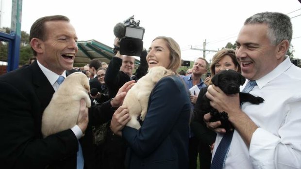 Opposition Leader Tony Abbott looks optimistic ahead of the polls during his visit to Guide Dogs Victoria with his daughter Frances Abbott, and shadow treasurer Joe Hockey.