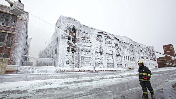 Firefighters spray down hot spots on an ice-covered warehouse that caught fire night in Chicago.