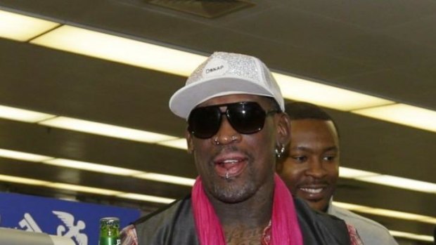 Former NBA basketball player Dennis Rodman holds a beer as he arrives at the Beijing Capital International Airport on a trip to North Korea.
