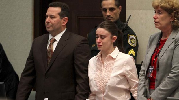 Case won ... Casey Anthony holds hands with her defence attorneys as they listen to the verdict.
