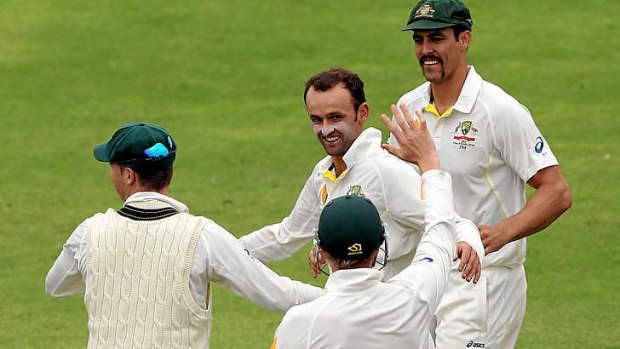 Come in spinner: Nathan Lyon of Australia is congratulated by teammates after he got the key wicket of Dean Elgar of South Africa during day one of the Second Test.