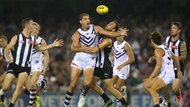 Aaron Sandilands is wrapped up by Collingwood's Brent Macaffer at during round 1 at Etihad Stadium.