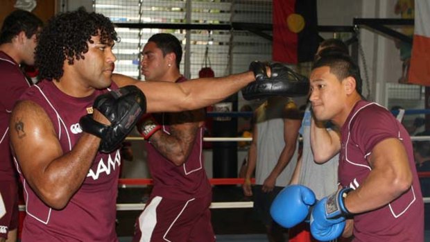Gym session ... Sam Thaiday, left, and Israel Folau spar at Maroons training yesterday.