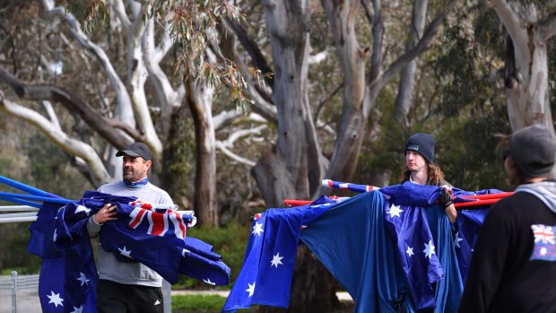 Protesters carry Australian flags to the Melton South rally.