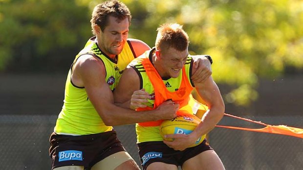 Under pressure: Luke Hodge tackles Andrew Boseley at training on Monday.