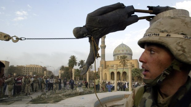 Iraqi civilians and US soldiers pull down a statue of Saddam Hussein in downtown Baghdad in 2003.