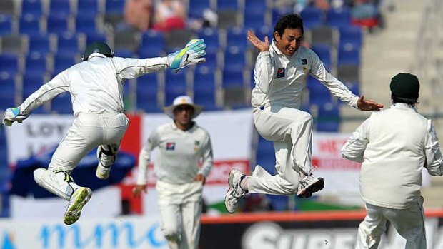 Pakistan's Saeed Ajmal (second from right) celebrates with teammates after dismissing England's Ian Bell in the second Test in Abu Dhabi.