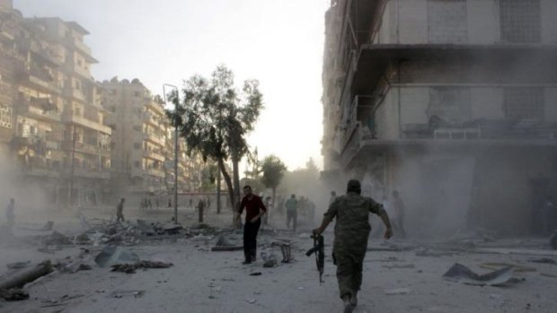 Syrians run for cover during an airstrike on the rebel-held neighbourhood of Bustan al-Qasr in  Aleppo.