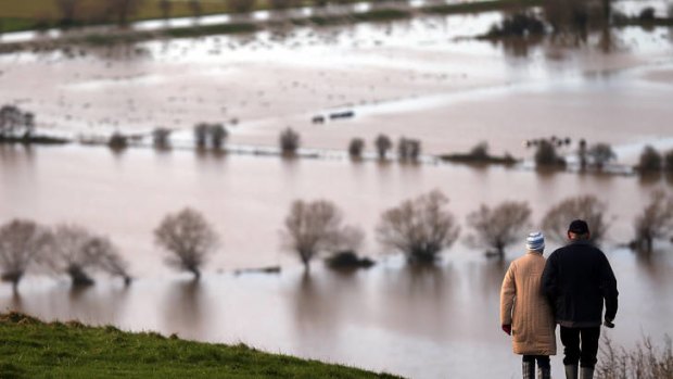 Water everywhere ... people walk from Glastonbury Tor above flooded fields, on Sunday in Somerset, England.