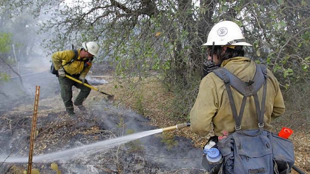 Firefighters make sure the last of the flames are out  as wildfires continue to burn west of Fort Worth, Texas.