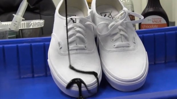 Chocolate sauce slides off a pair of white shoes that have been sprayed with NeverWet.
