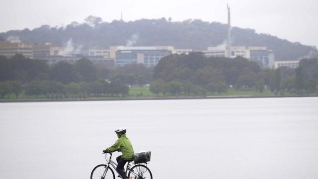 Break in the rain ... a cyclist braves the wet weather around the lake.