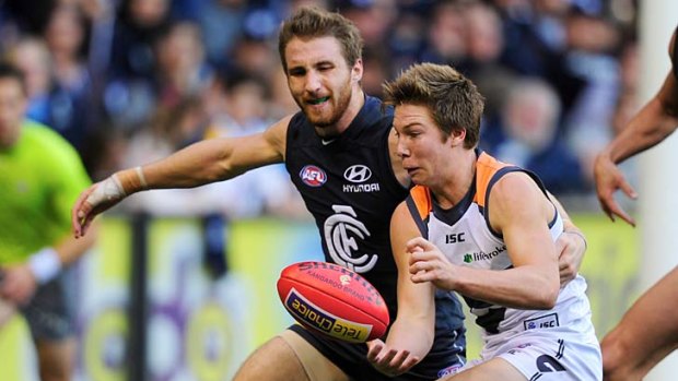 Under pressure: Toby Greene gets some close attention from Carlton's Zach Tuohy.