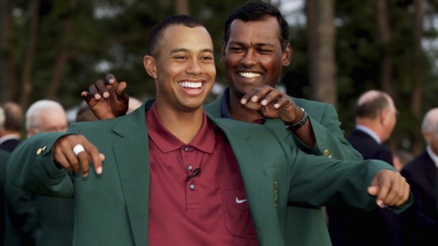 The slam ... Tiger Woods smiles as he receives the traditional green jacket from Vijay Singh after winning his second major.
