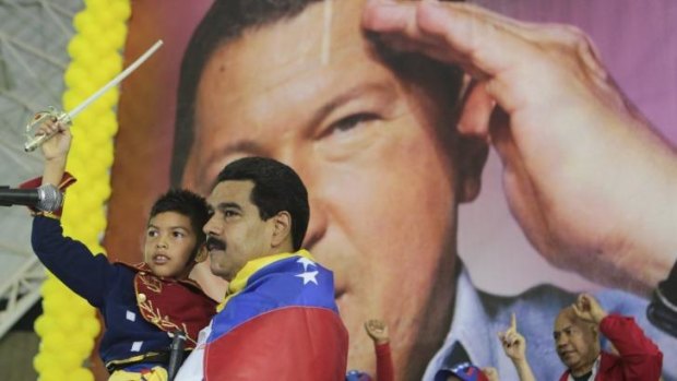 Venezuela's President Nicolas Maduro carries a child dressed up as national hero Simon Bolivar in front of a poster of the late president Hugo Chavez. The country adopted currency controls in 2003 to defend dwindling reserves against what Chavez had called "savage capitalists." 