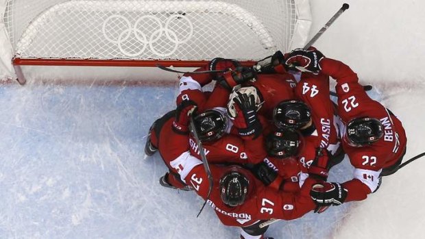 Jubilation: Canada's players congratulate goalie Carey Price after Canada defeated Team USA in their men's ice hockey semi-final.