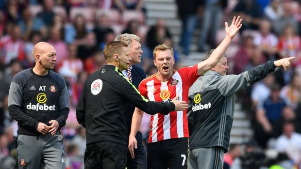 Sunderland's Sebastian Larsson argues with fourth official Mike Jones after being sent off against United.