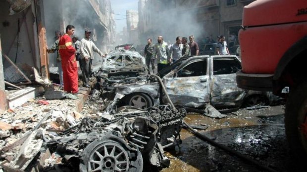 Picking up the pieces: The carnage after a car bomb in Homs.