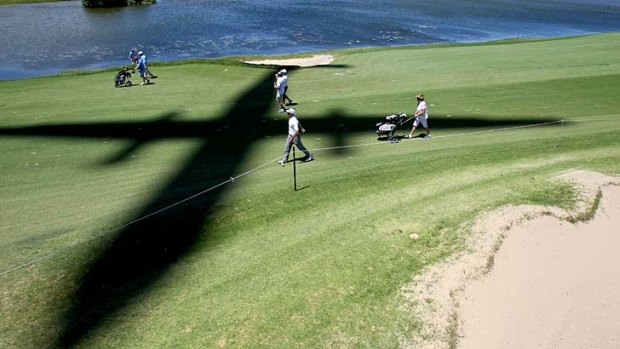A plane casts a shadow  over players in the Pro-Am at The Lakes Golf Club on Wednesday.