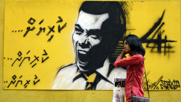 Roaring back: A woman walks past graffiti of former president Mohamed Nasheed in Male.