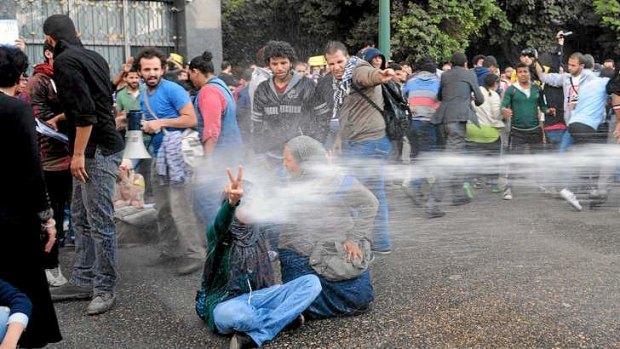 Police fire water cannons to disperse secular anti-government protesters in Cairo, the first implementation of a new law forbidding protests held without a permit.