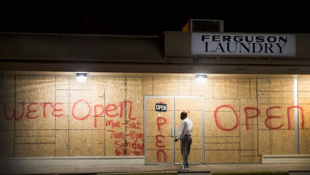 Plywood covers the glass front of shops in Ferguson.