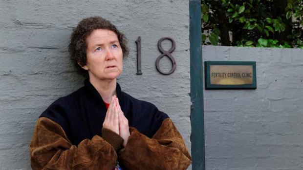 A woman protests through prayer outside the Fertility Control Clinic in East Melbourne.