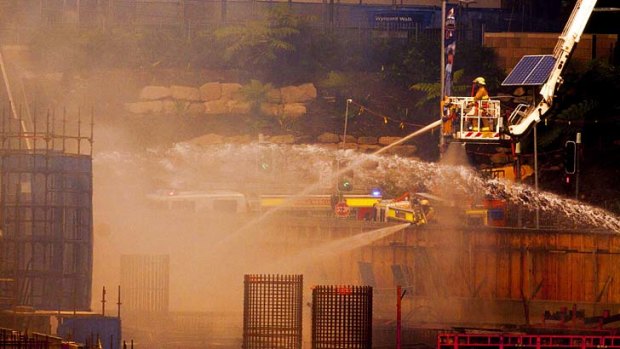 Vantage spot: Firefighters hose the flames from above at Barangaroo on Wednesday.
