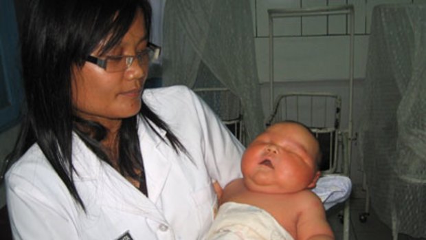 A doctor at the Medan hospital hefts Indonesia's heaviest newborn.