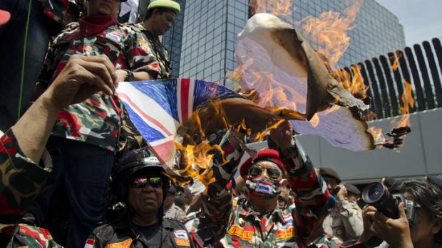 Protest: Uniformed Indonesian demonstrators angry over the tapping of their leader's phone burn a paper Australian flag outside the embassy in central Jakarta.