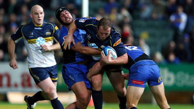 Purpose, cohesiveness and pace ... Ben Alexander of the Brumbies is tackled by the Force.