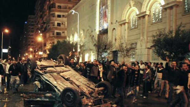 Worshippers in Alexandria shout around the exploded car in Alexandria.