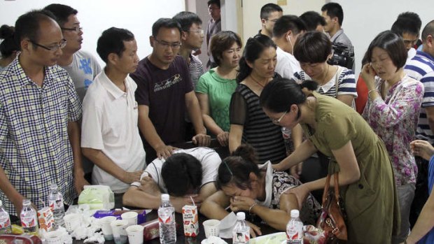 The parents of Wang Linjia are comforted by relatives of other students who were on Asiana Airlines Flight 214.