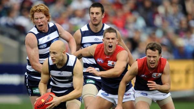 Melbourne's Brent Moloney and James McDonald try to catch Geelong's Gary Ablett.