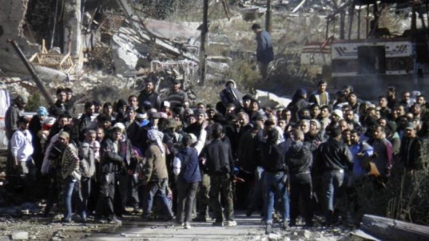Ceasefire: Civilians wait to be evacuated from a besieged area of Homs.