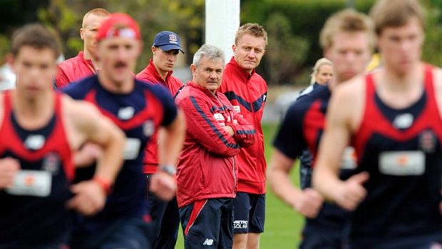 Time to sweat: Melbourne players train under the watchful eyes of Mark Neeld and  Neil Craig.