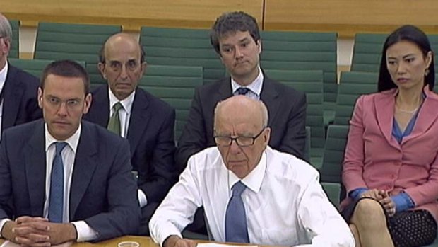Centre of a storm ... James and Rupert Murdoch at the parliamentary committee hearing.