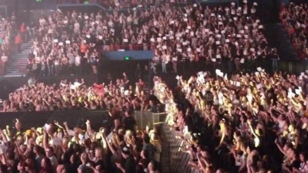 Fans hold up 'Still' signs at 5 Seconds of Summer concert.