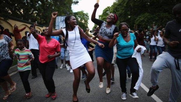People dance as a band plays outside the home of the former South African president Nelson Mandela.