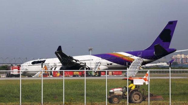Airport staff work around a Thai Airways plane that skidded off the runaway while landing at Bangkok's Suvarnabhumi Airport.